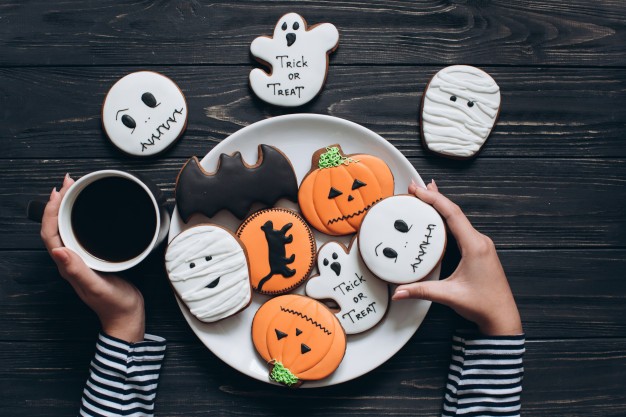 fille-se-prepare-pour-halloween-boire-du-cafe-manger-biscuits-effrayants_1429-1020